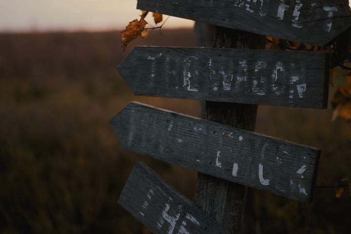 A wooden signpost at the edge of a field, one arm reading “The Wagon”